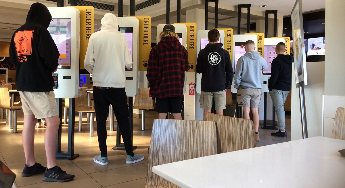 people lined up ordering self checkout fast food
